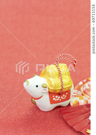 A cow carrying a bale of rice and a fan decoration A cow carrying a bale of rice and a fan decoration 69713158