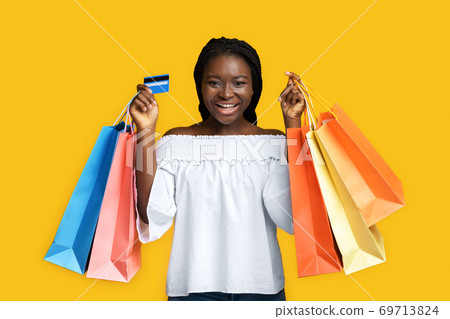 Big Shopping. Joyful Black Woman Posing With Shopper Bags And Credit Card Big Shopping. Joyful Black Woman Posing With Shopper Bags And Credit Card 69713824
