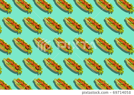 Healthy fast food and delivery for party. Hot dogs with sausages, salad and vegetables on turquoise background Healthy fast food and delivery for party. Hot dogs with sausages, salad and vegetables on turquoise background 69714058