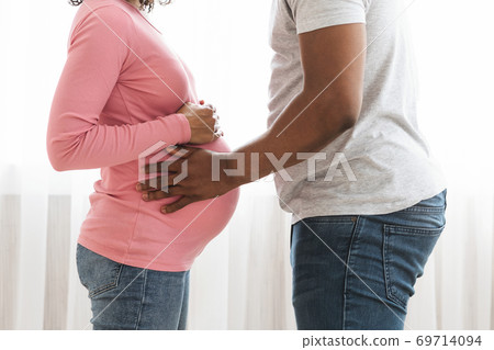 Closeup of african american pregnant couple embracing at home 69714094