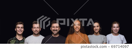 Group portrait of emotional people on black studio background 69714097