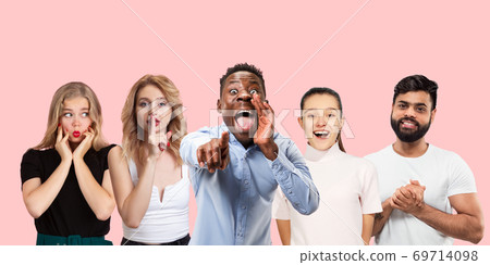Group portrait of emotional people on coral pink studio background 69714098