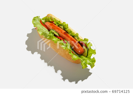 Fast and healthy snack food in menu for client. Delicious hot dog with grilled sausage, salad, cucumber and tomato with shadow isolated 69714125