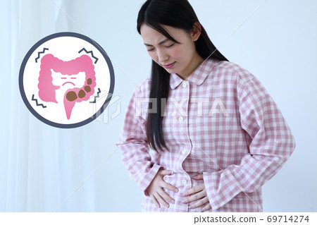 一個女人穿著睡衣痛苦的便秘的形象 69714274