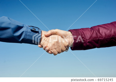 Handshake in medical gloves. Handshake in medical gloves. 69715245