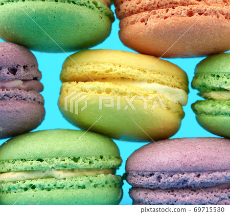 multi-colored round baked macarons cakes on a light blue background 69715580
