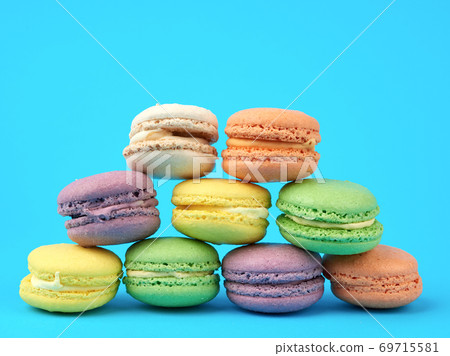 multi-colored round baked macarons cakes on a light blue background 69715581