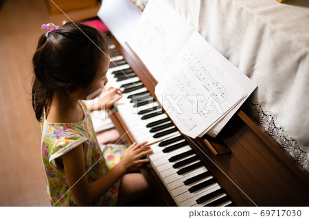 A child playing the piano 69717030