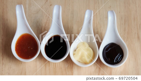 Various dip sauces serving on small cute short spoon on wooden table at Gourmet restaurant, advertisement backgrounds Various dip sauces serving on small cute short spoon on wooden table at Gourmet restaurant, advertisement backgrounds 69720504