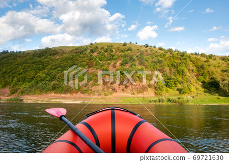 Orange packraft rubber boat with backpack on a river 69721630
