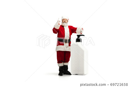 Santa Claus with the huge antiseptics against COVID like Christmas gift isolated on white background Santa Claus with the huge antiseptics against COVID like Christmas gift isolated on white background 69721638