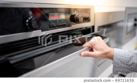 Male hand opening oven door Male hand opening oven door 69721639