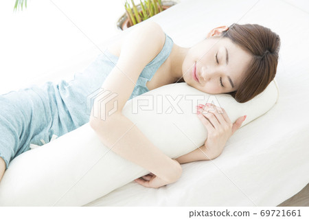 一個女人和一個抱著枕頭睡覺 69721661