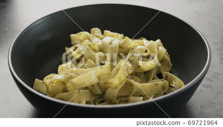 pesto fettuccine in black bowl on concrete countertop 69721964