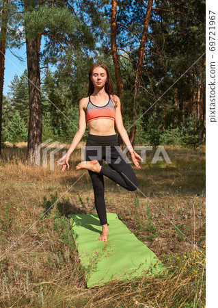 Beautiful young woman practicing yoga in the morning on the nature. Beautiful young woman practicing yoga in the morning on the nature. 69721967
