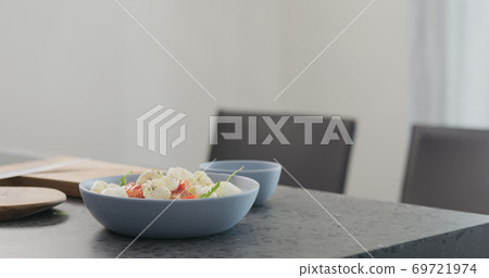 making salad in a blue bowl on concrete countertop on kitchen making salad in a blue bowl on concrete countertop on kitchen 69721974