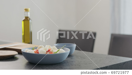 making salad in a blue bowl on concrete countertop on kitchen making salad in a blue bowl on concrete countertop on kitchen 69721977