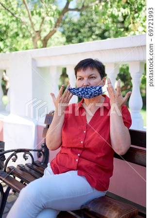 Beautiful mature european woman wearing handmade protective mask Beautiful mature european woman wearing handmade protective mask 69721993