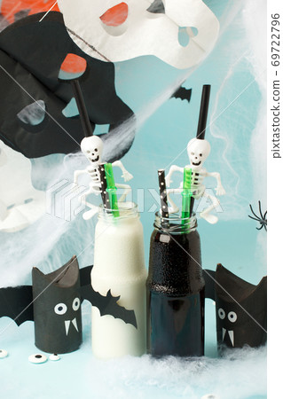 Colorful cocktails in glass bottles with skeleton straw on light blue background, Happy Halloween party banner, seasonal stylish holiday card, bright flyer 69722796