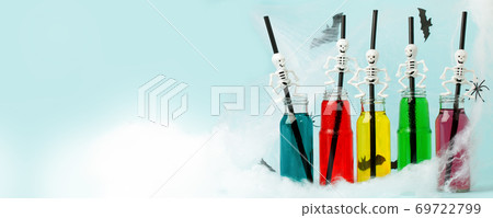 Colorful cocktails in glass bottles with skeleton straw on light blue background, Happy Halloween party banner, seasonal stylish holiday card, bright flyer Colorful cocktails in glass bottles with skeleton straw on light blue background, Happy Halloween party banner, seasonal stylish holiday card, bright flyer 69722799