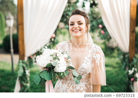 Bride holding big and beautiful wedding bouquet with flowers 69723318