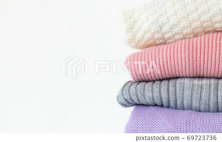 Stack of cozy knitted autumn or winter sweaters isolated on white background 69723736