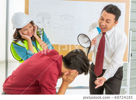 Unhappy Construction team Boss is shouting aggressively to his e 69724185