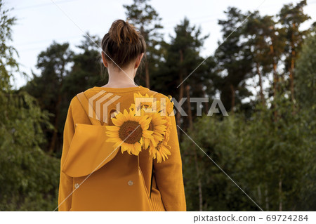 Girl with sunflowers in the autumn nature enjoys mindfulness 69724284