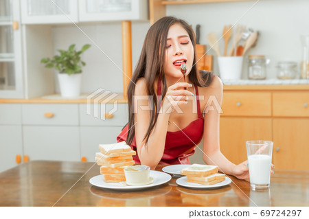 Seductive woman wearing only apron is eating Seductive woman wearing only apron is eating 69724297