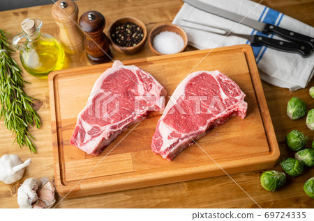raw steak meat on cutting board in bright kitchen 69724335