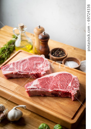 raw steak meat on cutting board in bright kitchen 69724336