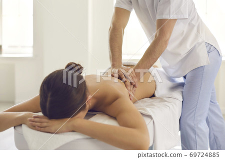 Woman lying on massage table getting medical back massage in modern physiotherapy center 69724885