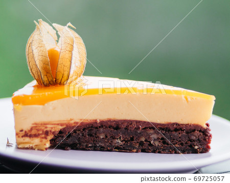 Closeup of delicious peach cake on the plate on green bokeh background Closeup of delicious peach cake on the plate on green bokeh background 69725057