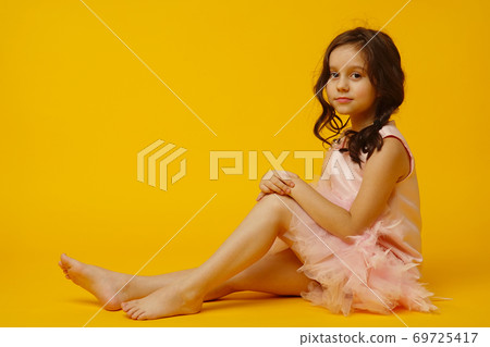 Photo of smiling little girl child isolated over yellow background. 69725417