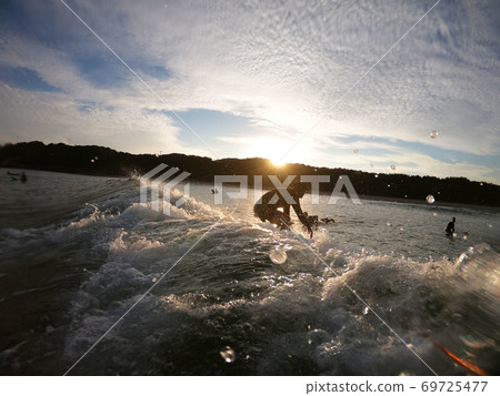 GoPro shooting, surfer taking off towards the morning sun 69725477