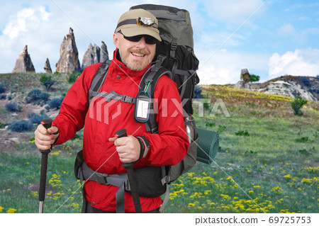 Happy tourist with backpack is traveling in the highlands. Volcanic rocks in Cappadocia valley 69725753