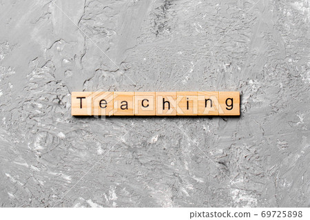 TEACHING word written on wood block. TEACHING text on cement table for your desing, concept TEACHING word written on wood block. TEACHING text on cement table for your desing, concept 69725898