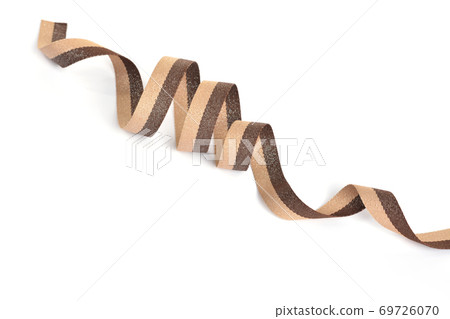 Brown beige Cotton ribbon, roll textilies on bobbin. strapping tape with curl on white backgroud. 69726070