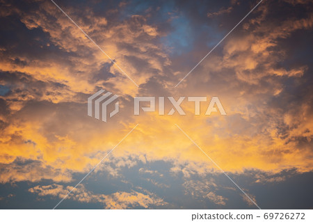 Celestial World concept. Fiery dark yellow colorful natural bright dramatic sunset sky with clouds. Background natural color of evening cloudscape panorama. Ideal for design wallpaper 69726272
