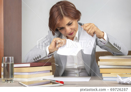 Beautiful business woman tearing white paper in half 69726287