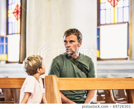 Christian dad tells his son Bible stories about Jesus sitting in kirk. Faith, religious education, modern church, father day, fatherly responsibilities, father influence on formation of son worldview Christian dad tells his son Bible stories about Jesus sitting in kirk. Faith, religious education, modern church, father day, fatherly responsibilities, father influence on formation of son worldview 69726301