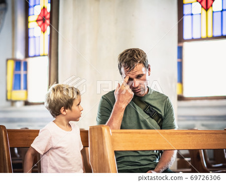 Christian dad tells his son Bible stories about Jesus sitting in kirk. Faith, religious education, modern church, father day, fatherly responsibilities, father influence on formation of son worldview 69726306
