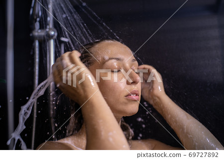 Calm and balanced young woman hair taking shower with shampoo foam 69727892