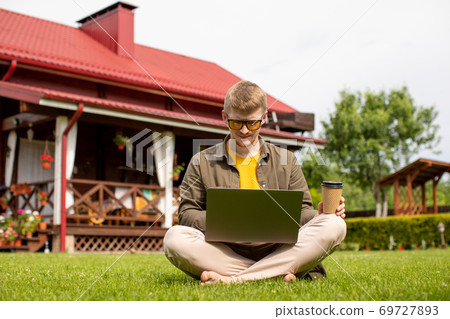 male student searching information for homework using wifi connection outdoors male student searching information for homework using wifi connection outdoors 69727893