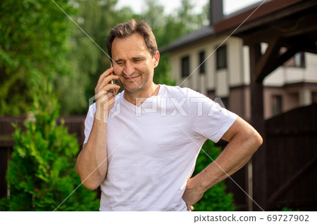 Happy middle aged man talking by smartphone, smiling man standing outdoors Happy middle aged man talking by smartphone, smiling man standing outdoors 69727902