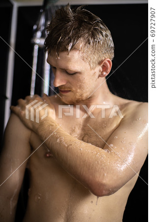 Young handsome guy bathing, naked man washing body with shower gel 69727907