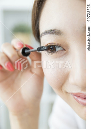 A woman applying mascara 69728798