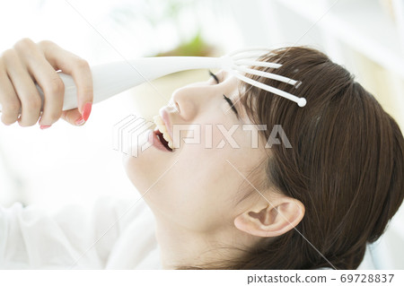 A woman with a scalp massage A woman with a scalp massage 69728837