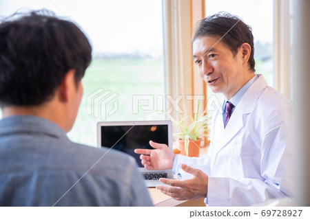 Doctor examining a man 69728927