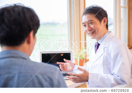 Asian doctor examining a man 69728928